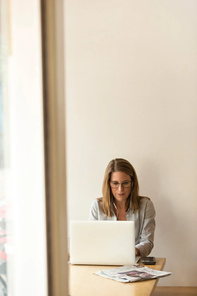 Woman using laptop with headphones demonstrating Avodah Dynamics feedback loops in performance apparel