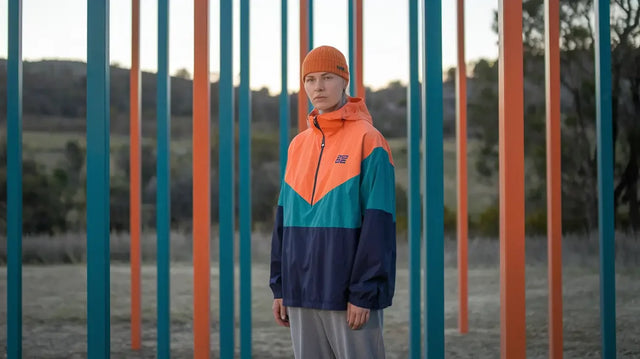 Emotionally intelligent leader in color-blocked windbreaker, embodying transformational leadership