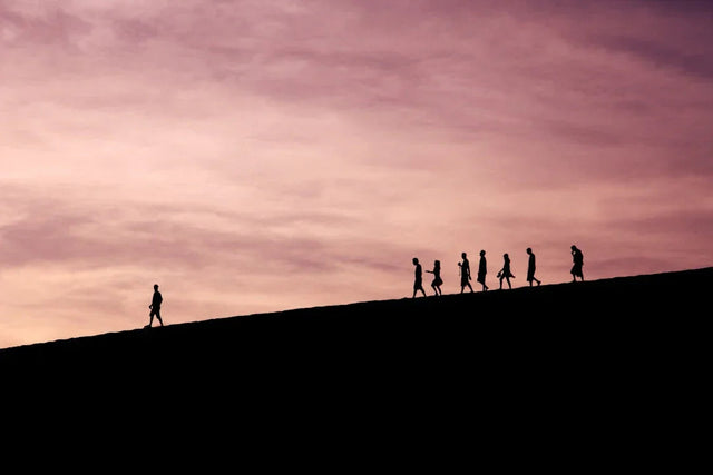 Silhouettes of people walking on hillside, symbolizing ethical leadership redefines trust