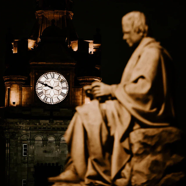 Serene stone statue and clock tower at night, inspiring mindfulness practices