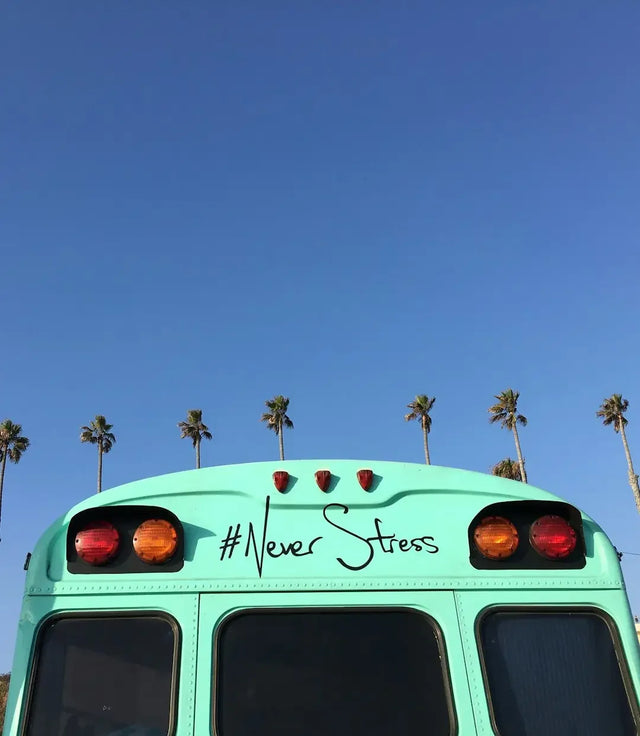 Mint green school bus promoting mental health awareness with Never Stress slogan