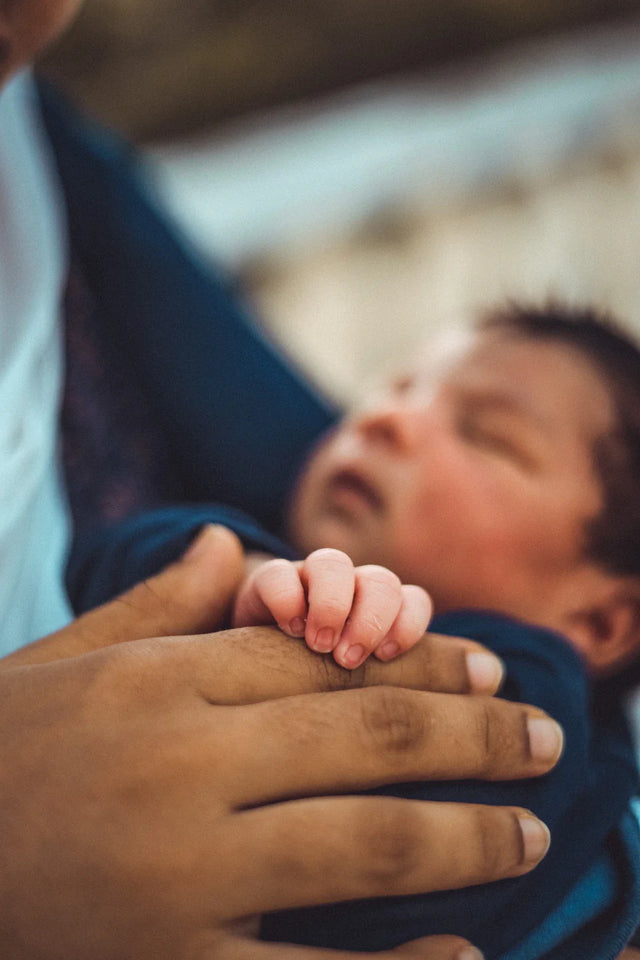 Tiny baby’s hand grasping adult’s finger illustrating trust aligned with Avodah Dynamics core values