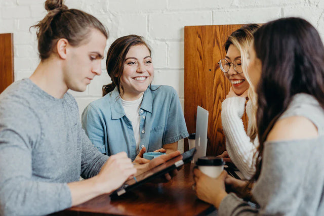 Four young adults celebrating small wins to encourage team members and boost team motivation