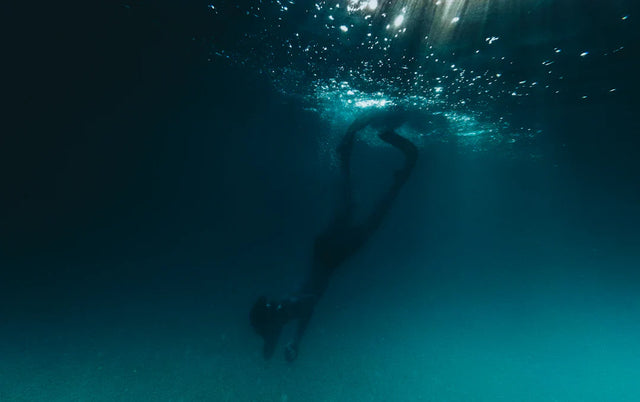 Silhouette of a person swimming underwater symbolizing setting smart goals and ambition statement