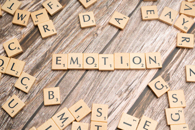 Wooden letter tiles spelling EMOTION representing emotional intelligence and active listening