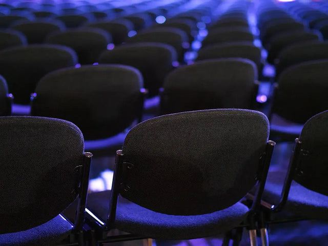 Auditorium with dark upholstered chairs illustrating Avodah Dynamics for authentic relationships