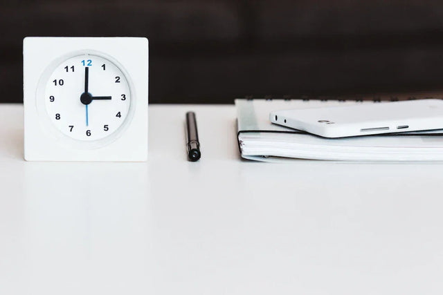 White analog clock with blue second hand symbolizing effective time management strategies