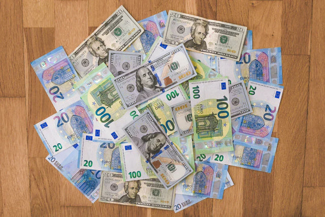 Pile of U.S. dollar and Euro banknotes representing financial planning and financial goals