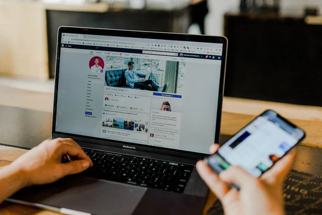 Person’s hands using a silver MacBook Pro displaying social media for marketing messages and buyer personas