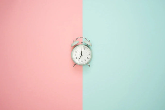 Light blue alarm clock with white face illustrating time management strategies for entrepreneurs