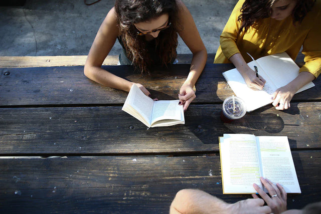 Students studying at a wooden table enhancing vision communication and retention rates