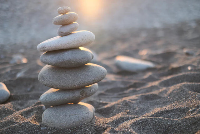 Stacked stones symbolizing balance in hustle culture and social responsibility within Avodah Dynamics