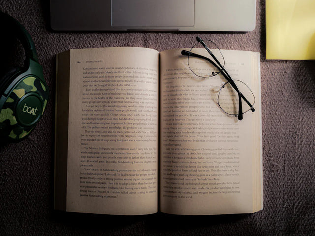 Open book with reading glasses symbolizing overcoming impostor syndrome in Avodah Dynamics