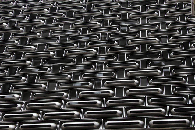 Dark metallic perforated security shutter representing personal growth beyond hustle culture