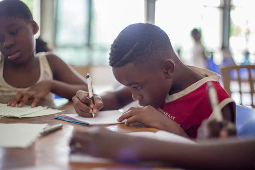 Students focused on writing at desks to foster community engagement and support student retention