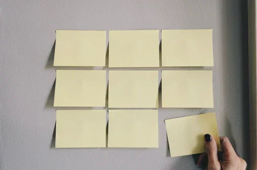 Yellow sticky notes arranged in a grid for strategic planning process to improve retention rates
