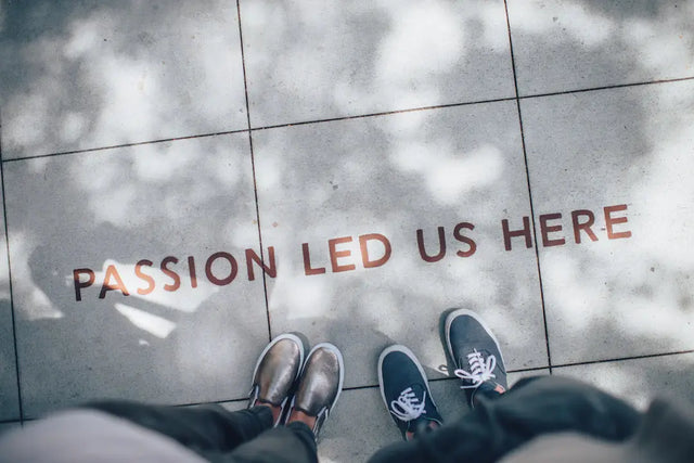 Text on floor reading PASSION LED US HERE with shoes beneath, illustrating the transformative power of a strong school vision