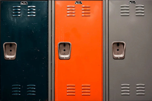Metal lockers in dark green orange and gray representing Avodah Dynamics for connecting school vision