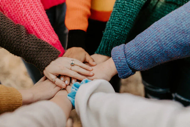 Hands stacked together in unity representing a purpose-driven community by Avodah Dynamics