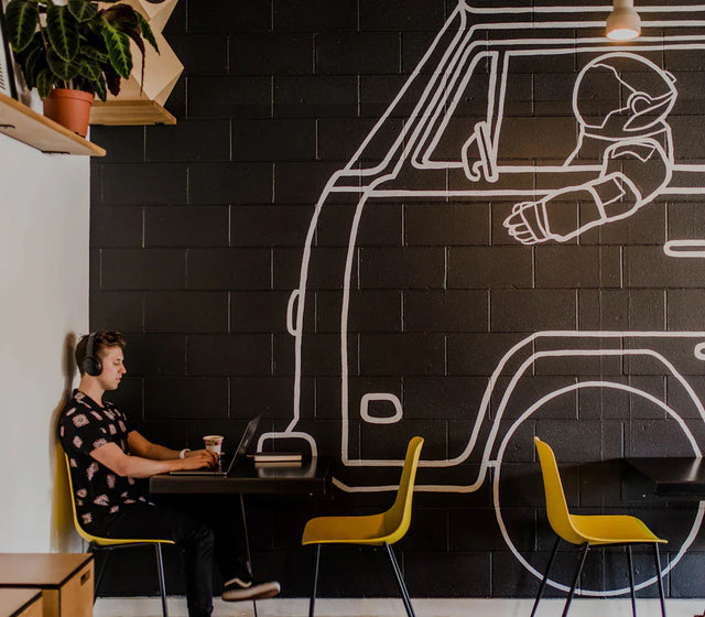 Person working on a laptop at a cafe table illustrating key performance indicators for online store success