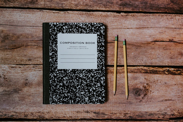 Black and white marbled composition book with white label symbolizing continuous learning and personal growth
