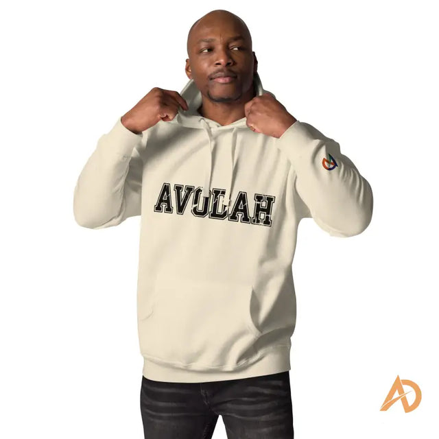 Avodah Varsity Hoodie in cream cotton blend designMan adjusting collar of beige AVULAH hoodie with bold black collegiate letters, AD logo on sleeve.