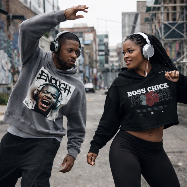 Two people wearing graphic sweatshirts and headphones on a city street.