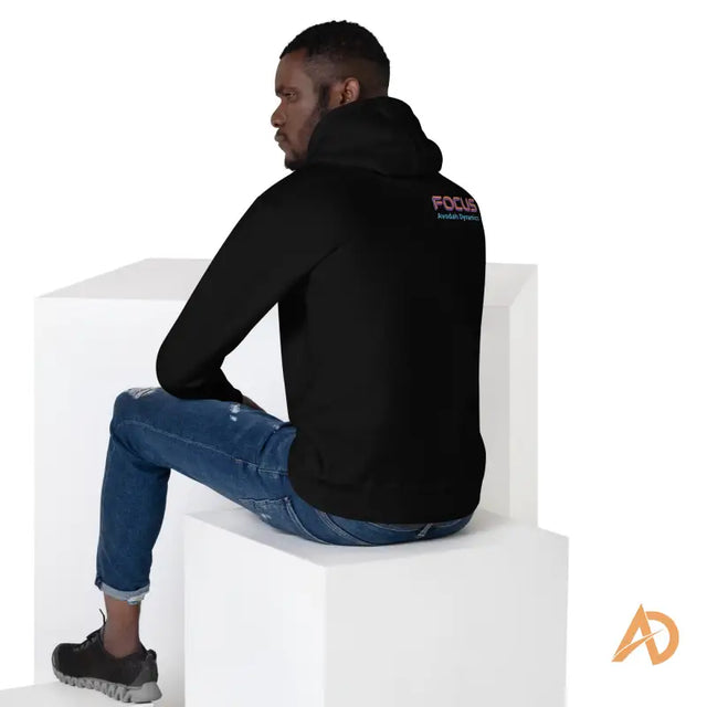 Galaxy Focus Hoodie by Avodah Dynamics: black cotton with focus and Australia’s Premier text on backMan in black hoodie with 'FOCUS Avodah Dyranic' sitting thoughtfully on white cubes with orange AD logo.