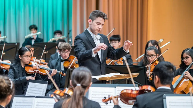 Orchestra conductor leading musicians, embodying avodah dynamics in community engagement.