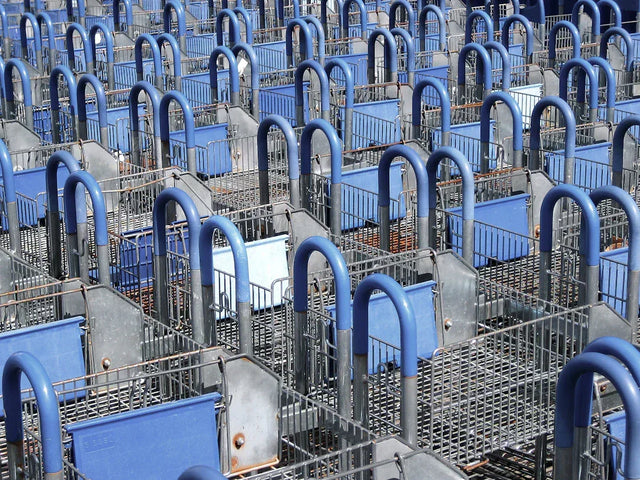 Nested blue-handled shopping carts for e-commerce sales goals success