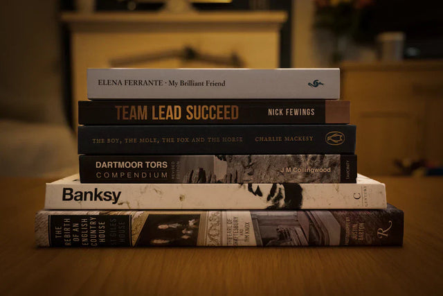 Stack of Avodah Dynamics motivational books on wood