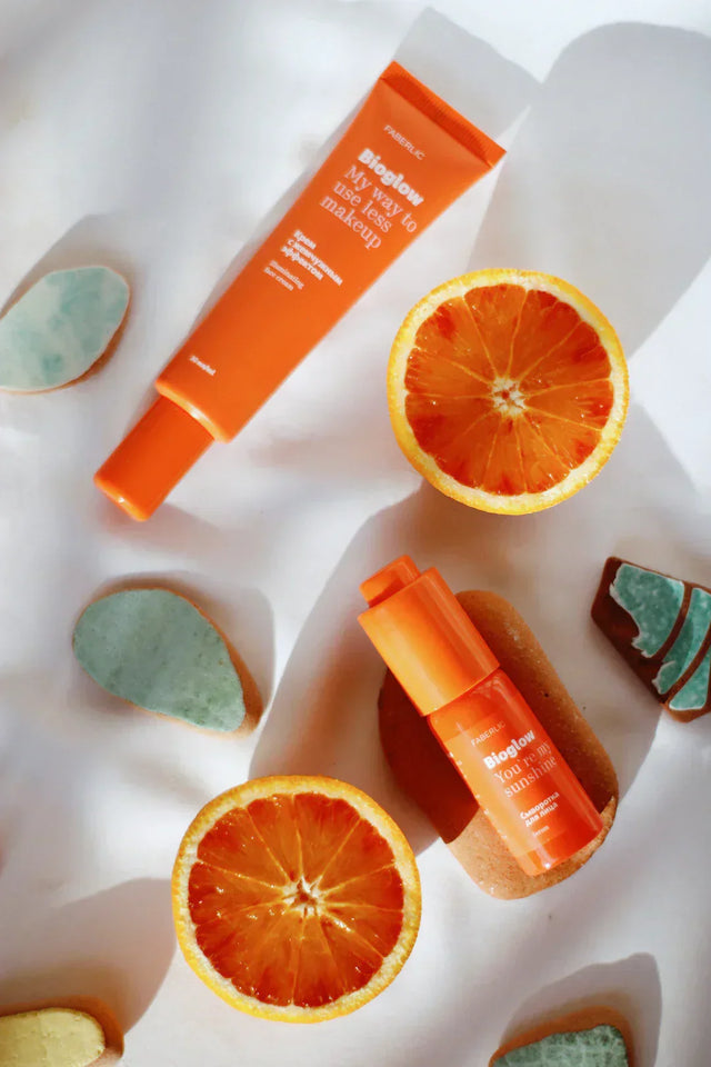 Orange skincare products with sliced oranges, styled for consumer-centric design.