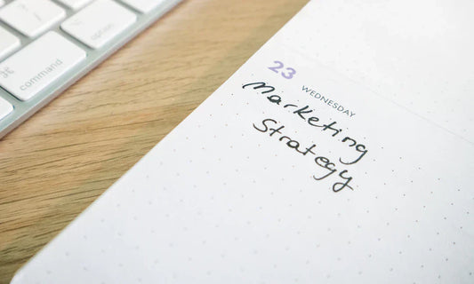 White notepad with dotted grid and handwritten marketing strategy note for Wednesday 23rd