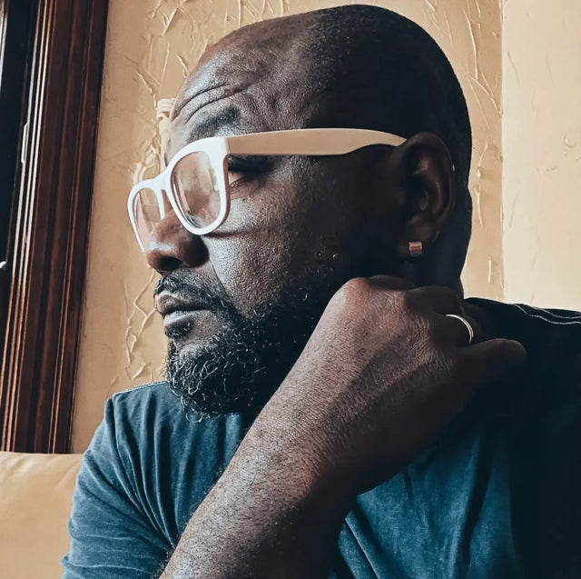 Contemplative leader in glasses celebrates progress in 2024