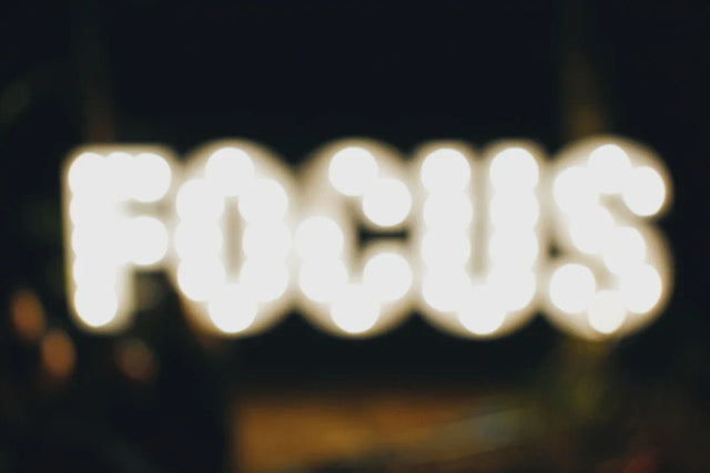 Blurry illuminated sign spelling out FOCUS representing Avodah Dynamics and professional growth