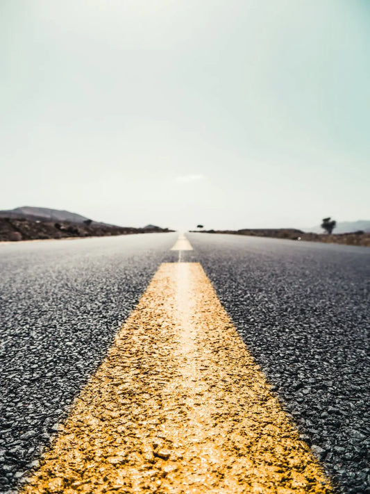 Yellow double line on asphalt road symbolizing success and cultivating happiness.