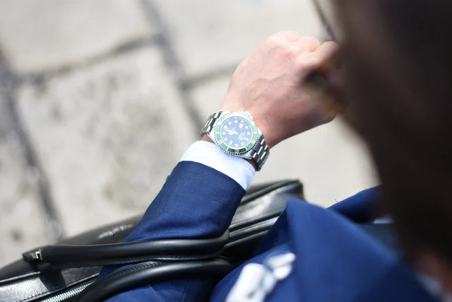 Wrist with stainless steel watch over white shirt cuff and blue suit in Building Resilience article