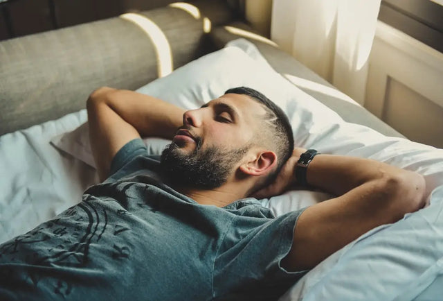 Person sleeping peacefully on white bedding, highlighting optimizing rest and sleep quality in hustle culture.