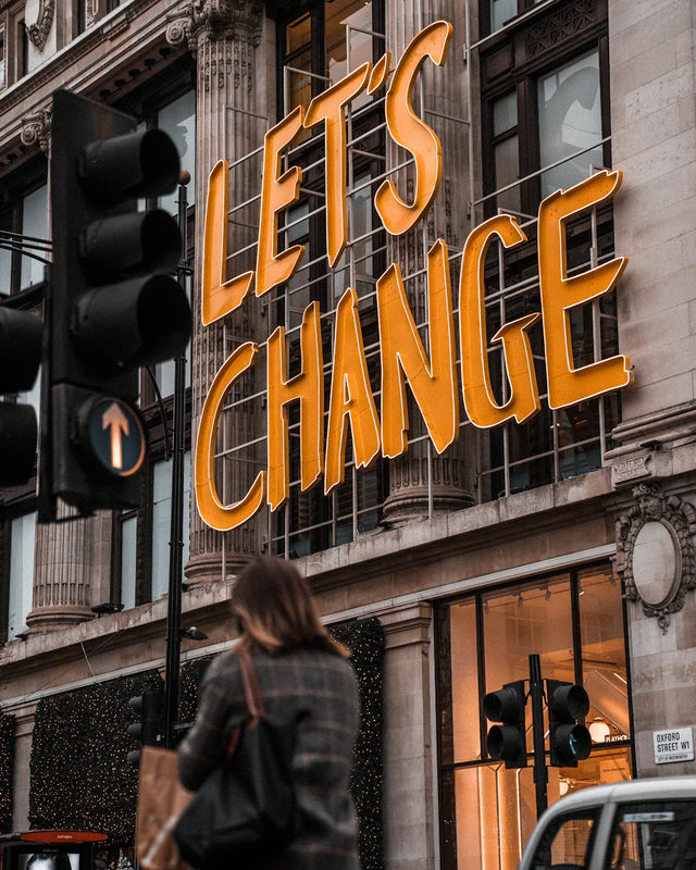 Orange LETS CHANGE sign on building symbolizing embracing change and growth mindset