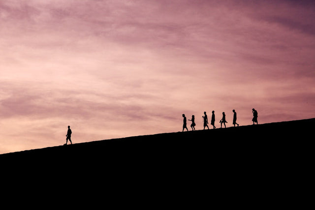 Silhouettes of people walking symbolize ethical leadership and trust in organizations.