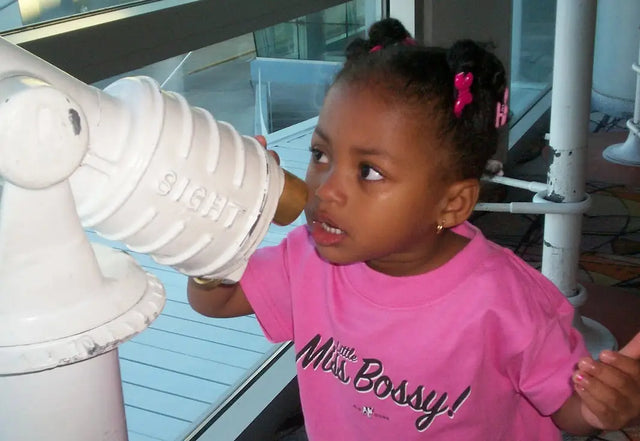 Child in bright pink Miss Bossy t-shirt, embodying purpose-driven leadership in early years.