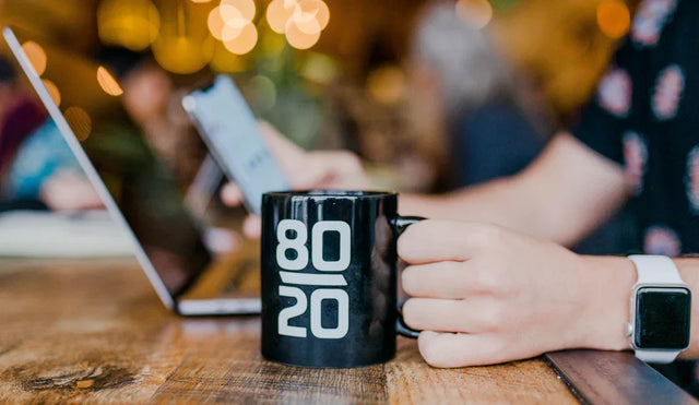 Black ceramic coffee mug with 80/20 in white, symbolizing hustle culture and personal growth