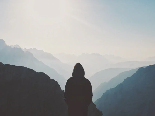 Person in hooded jacket overlooking mountain ranges, illustrating identifying opportunities