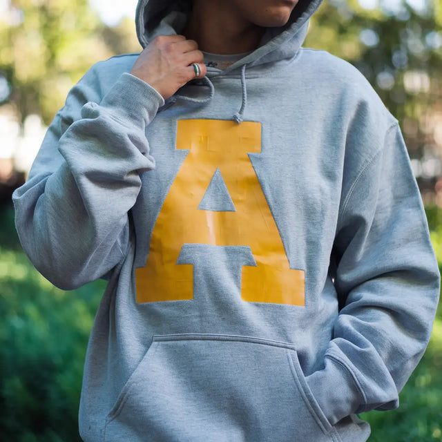 Grey hoodie sweatshirt featuring yellow letter A design, ideal for stress management techniques.