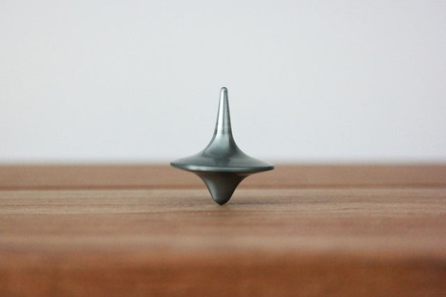 Metal spinning top symbolizes professional growth and leadership skills in Hustle Culture.