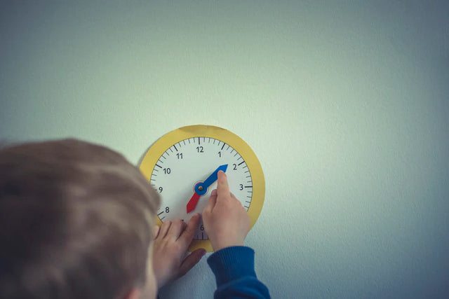 Child’s hands adjusting a toy clock illustrating a continuous learning mindset for success