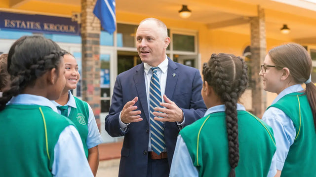 Individual in navy suit engages group in green uniforms on emotional connection strategies.