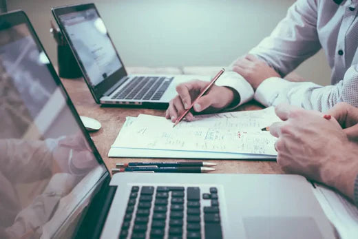 Two individuals collaborating at a table to enhance work-life balance and reduce stress.