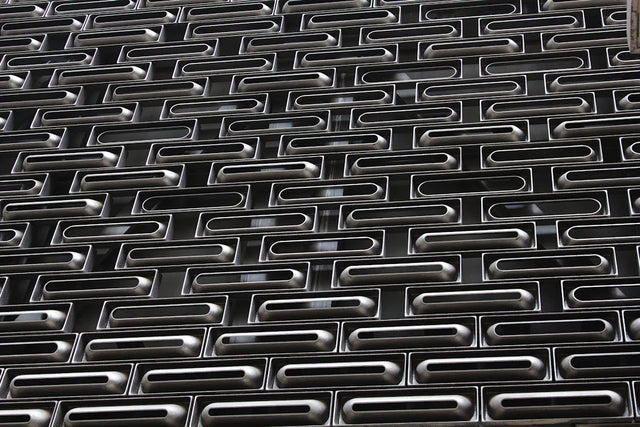 Dark metallic perforated security shutter representing personal growth beyond hustle culture