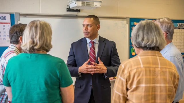 Person in navy suit delivering insights on crisis management for school’s vision.